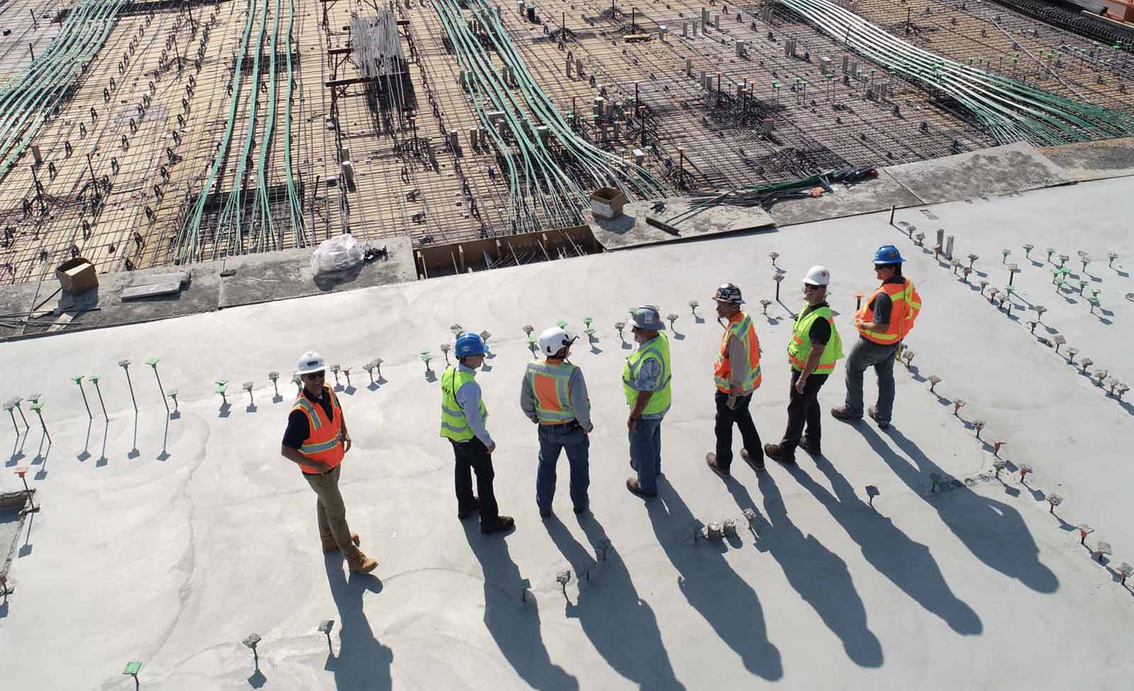 Bauarbeiter stehen auf einer großen Baustelle für's Tablet