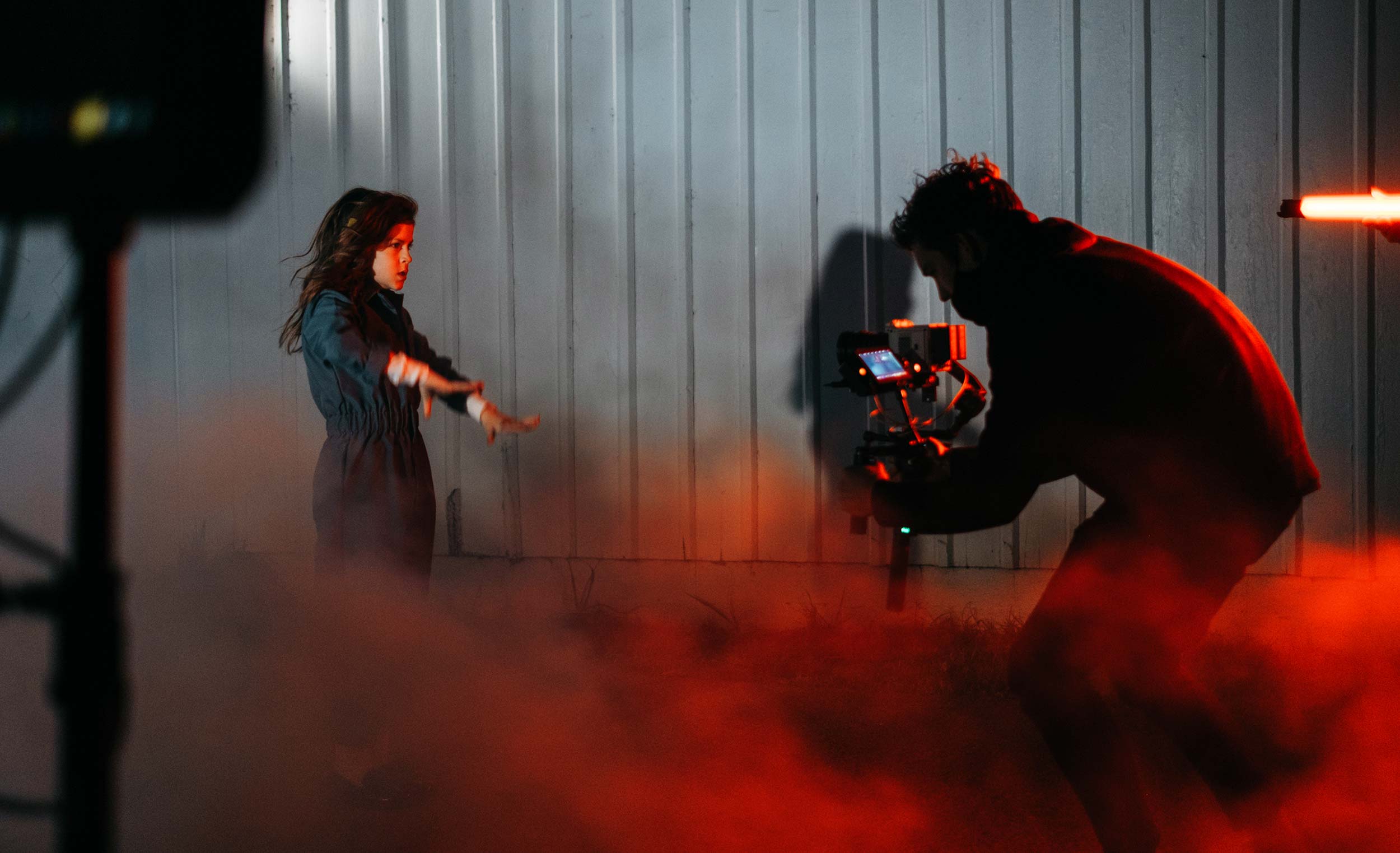 Mann filmt Frau im rotem Rauch für Desktop